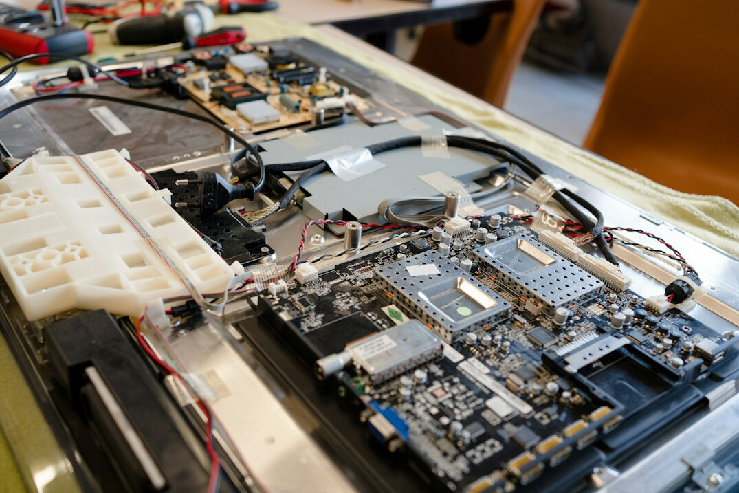 Group of people working on laptops in a workshop